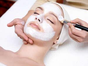 Woman having facial mask at beauty salon Medispa Services - Facial